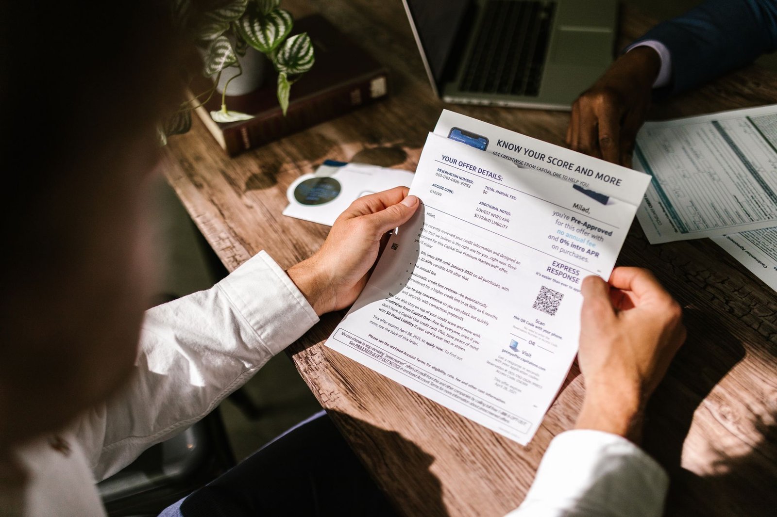 Veteran reading a VA disability reexamination notice letter at the kitchen table